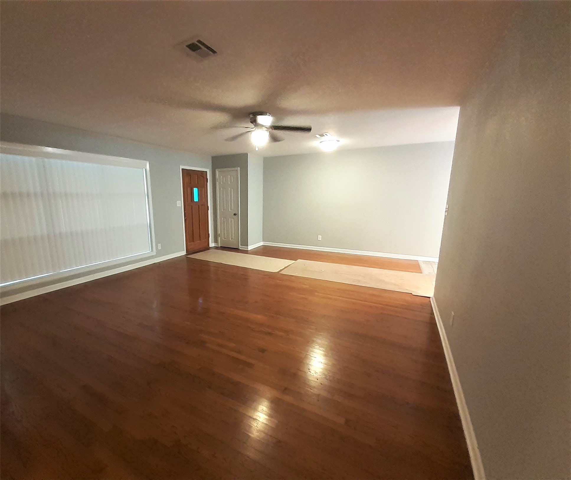 1213 Tobola Street Rosenberg, TX 77471 - Photo 2 of 8 an empty room with wooden floor and windows