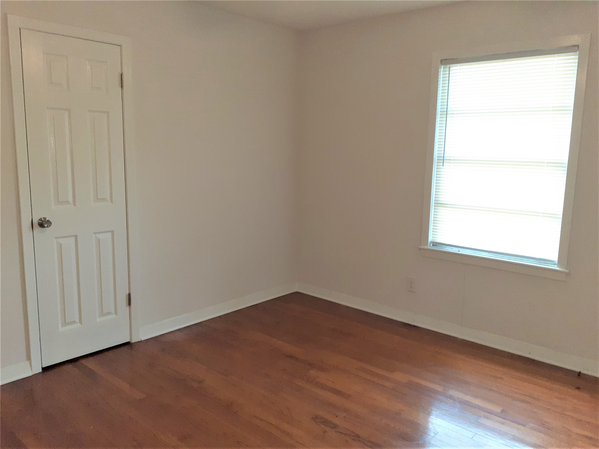 1213 Tobola Street Rosenberg, TX 77471 - Photo 4 of 8 wooden floor in an empty room with a window