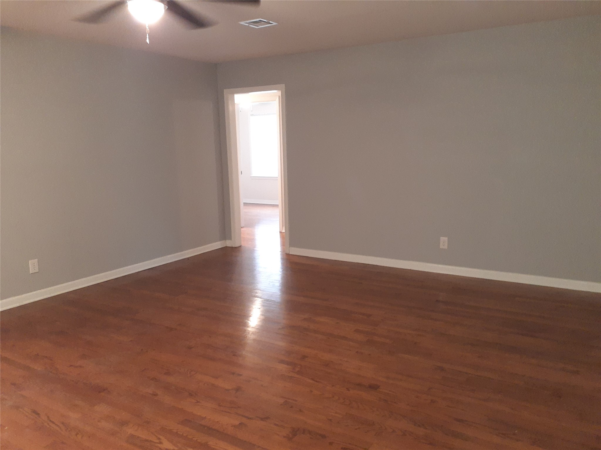 1213 Tobola Street Rosenberg, TX 77471 - Photo 5 of 8 a view of an empty room with wooden floor and windows