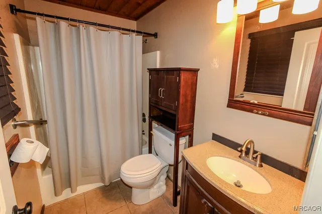 en suite bathroom with toilet sink and mirror