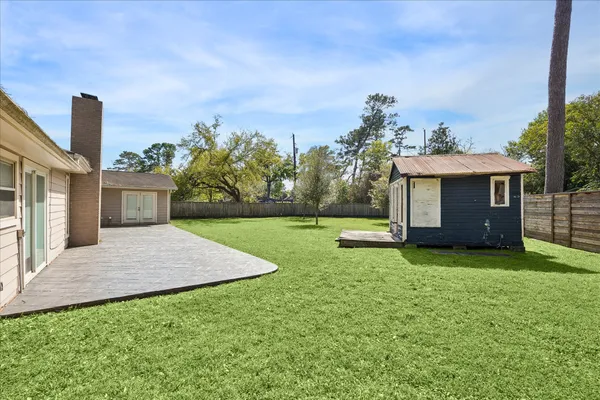 a view of a house with backyard and a tree