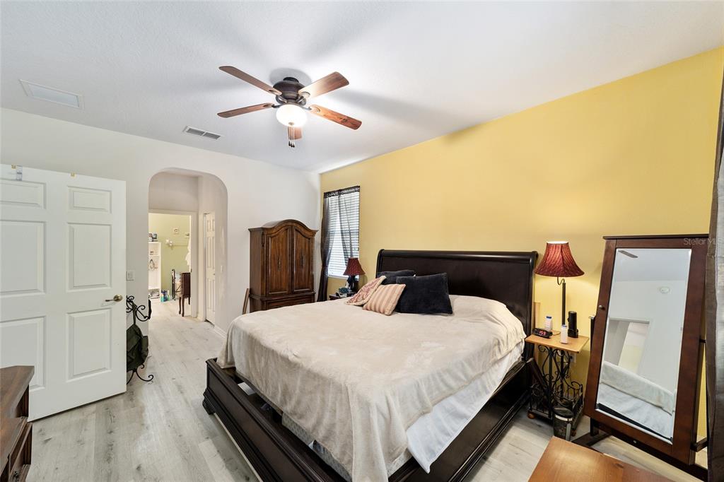 8364 Southwest 79th Circle Ocala, FL 34476 - Photo 14 of 40 a bed room with a bed and a chandelier