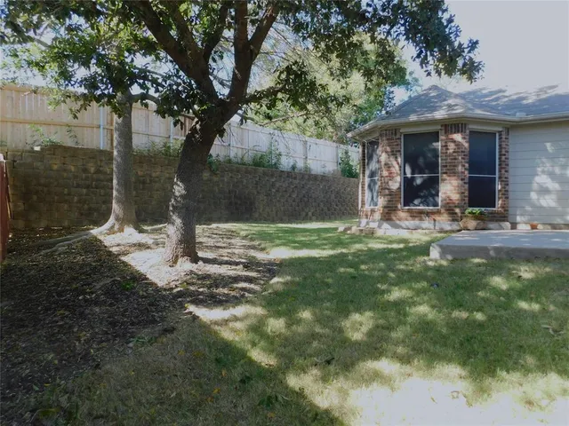 a view of a chair and table in backyard of the house