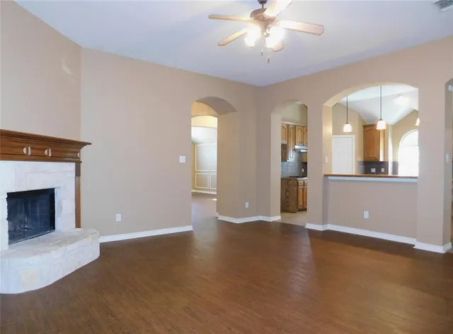 a view of a livingroom with wooden floor and a fireplace