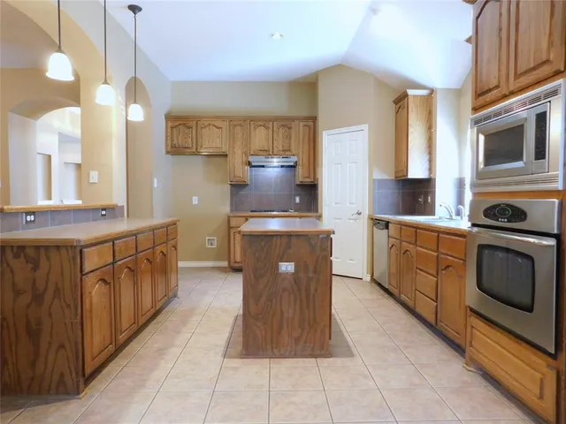 a kitchen with stainless steel appliances a sink stove and cabinets
