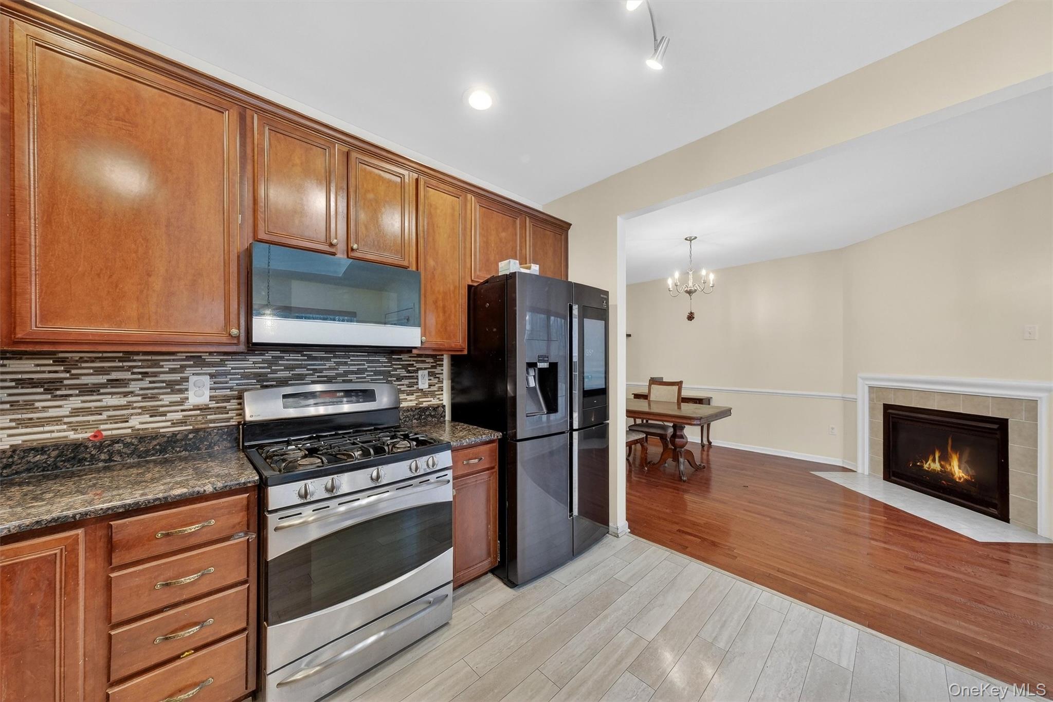 1123 Cold Spring Road Fishkill, NY 12524 - Photo 16 of 44 a kitchen with granite countertop wooden floors stainless steel appliances and cabinets