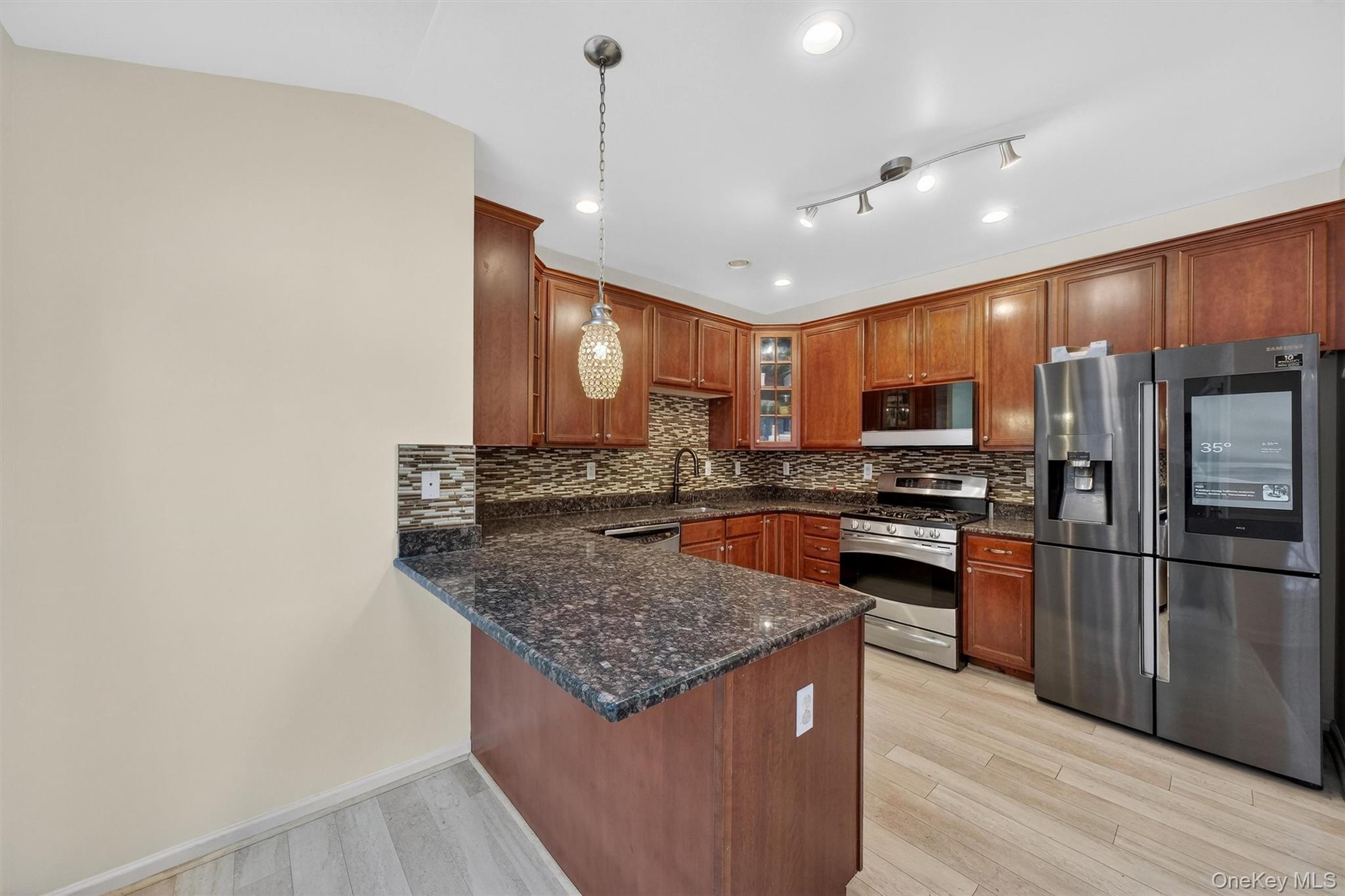 1123 Cold Spring Road Fishkill, NY 12524 - Photo 17 of 44 a kitchen with stainless steel appliances granite countertop a refrigerator a sink dishwasher a stove with wooden cabinets and wooden floor