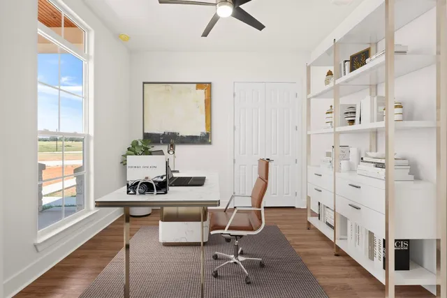 a view of a workspace with furniture and a window