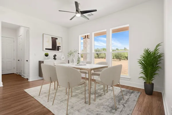 a dining room with furniture potted plants and wooden floor