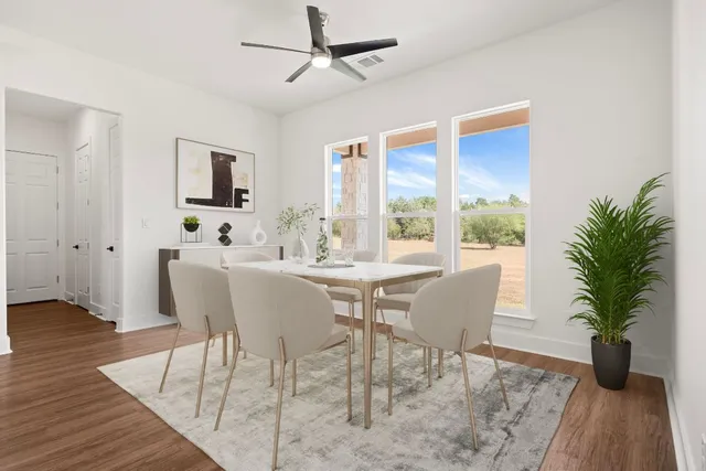 a dining room with furniture potted plants and wooden floor