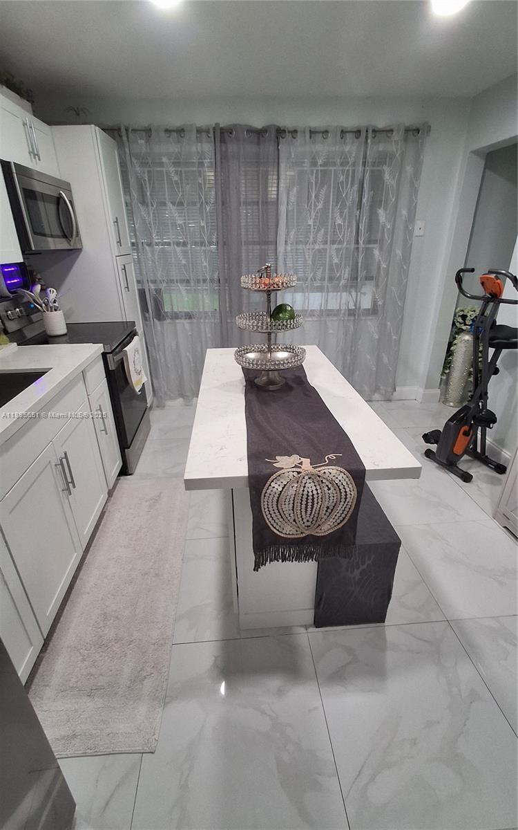 10305 Southwest 149th Terrace Miami, FL 33176 - Photo 23 of 39 a living room with furniture a rug and white walls