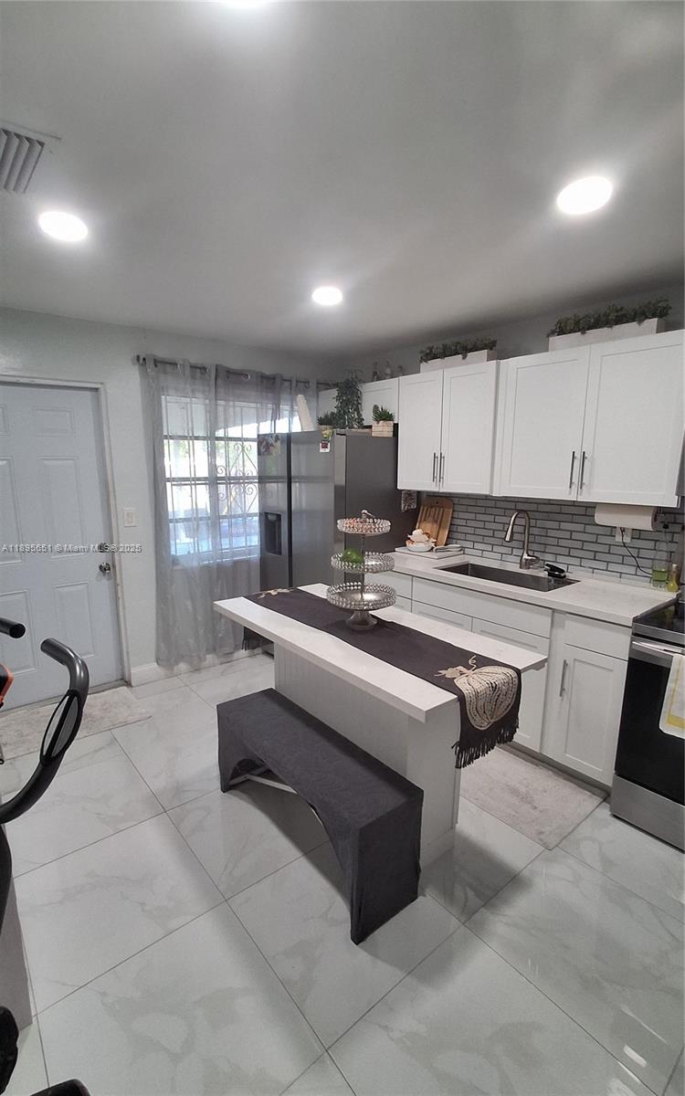 10305 Southwest 149th Terrace Miami, FL 33176 - Photo 24 of 39 a kitchen with granite countertop a stove a sink and a refrigerator