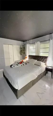 a bed sitting in a bedroom next to a window