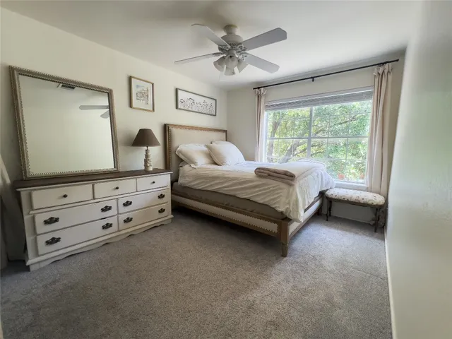 a spacious bedroom with a bed and a chandelier