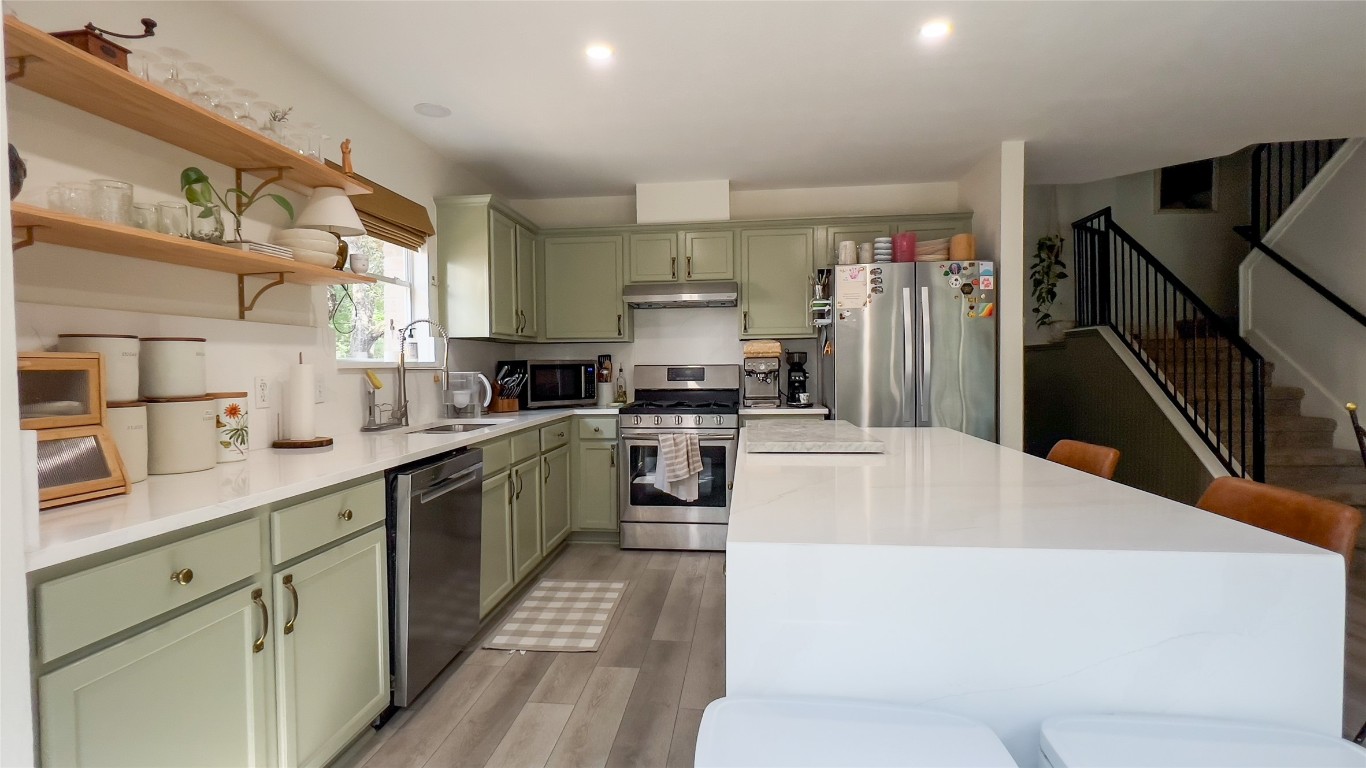 8908 West Hove Loop Austin, TX 78749 - Photo 4 of 20 a kitchen with stainless steel appliances a white stove top oven a sink and a refrigerator