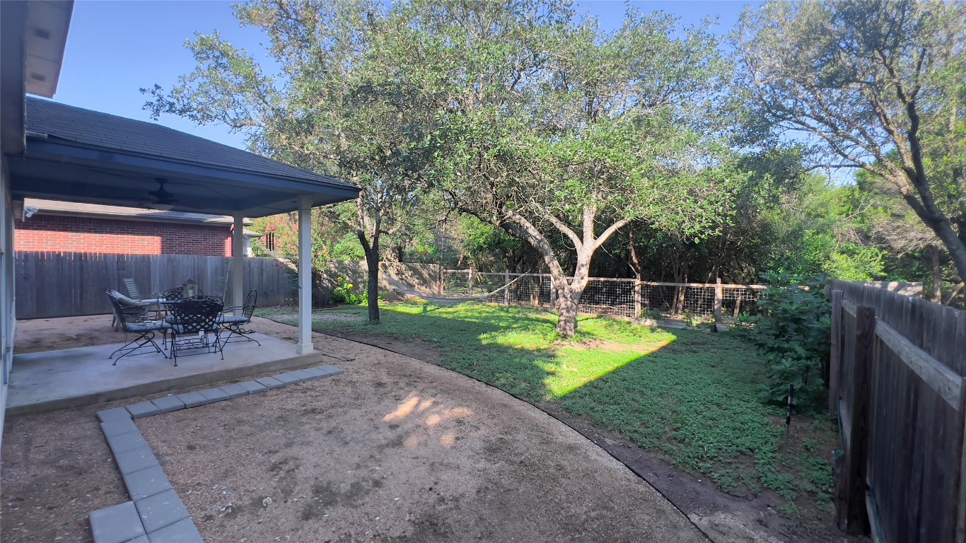 8908 West Hove Loop Austin, TX 78749 - Photo 7 of 20 a view of a backyard with table and chairs under an umbrella with a small yard