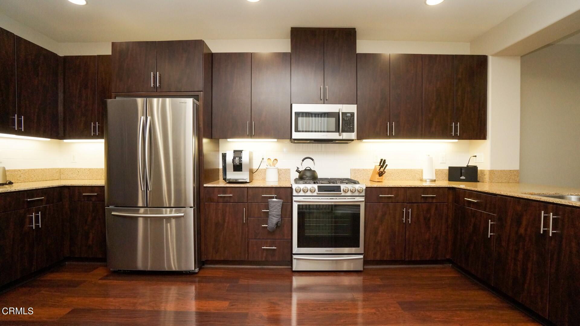 729 Forest Park Boulevard Oxnard, CA 93036 - Photo 7 of 27 a kitchen with kitchen island granite countertop stainless steel appliances and wooden cabinets