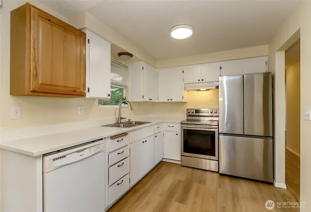 a kitchen with stainless steel appliances granite countertop a refrigerator sink and cabinets