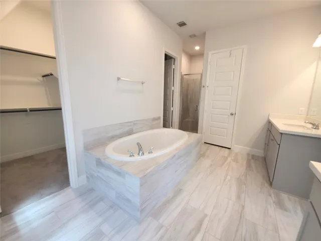 a spacious bathroom with a tub shower and sink