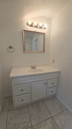 a bathroom with a sink vanity and mirror