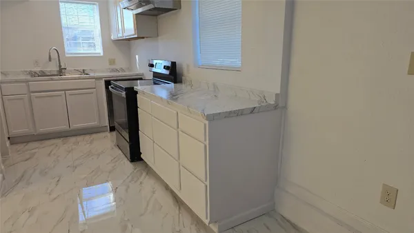 a kitchen with a sink cabinets and a window