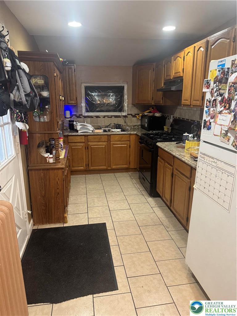 911 Marion Street Reading, PA 19604 - Photo 16 of 16 a kitchen with a sink a stove a microwave and cabinets