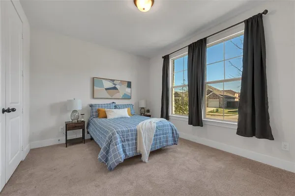 a spacious bedroom with a bed and a large window