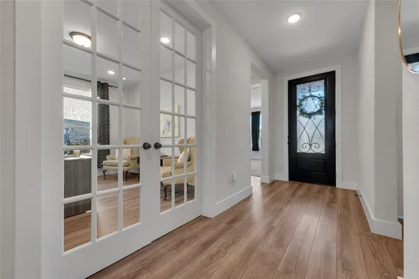 a view of a hallway with wooden floor and windows