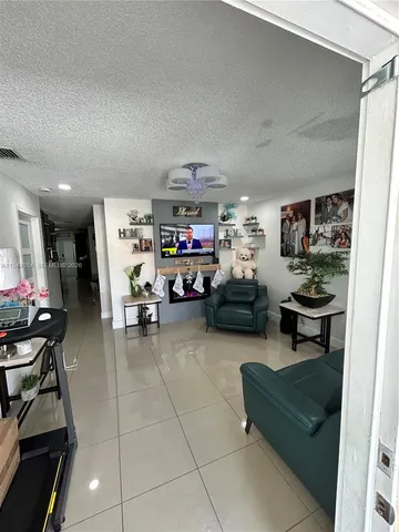 a living room with furniture and a gym machine