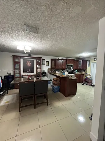 a living room with lots of furniture and view of kitchen
