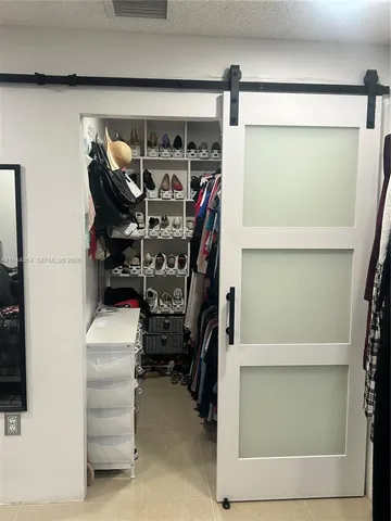 a view of walk in closet with clothes and shoes