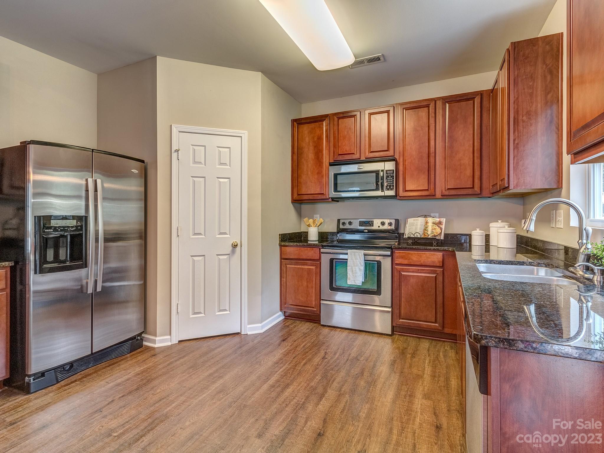 1119 Spicewood Pines Road Fort Mill, SC 29708 - Photo 20 of 38 a kitchen with granite countertop wooden floors stainless steel appliances and a window