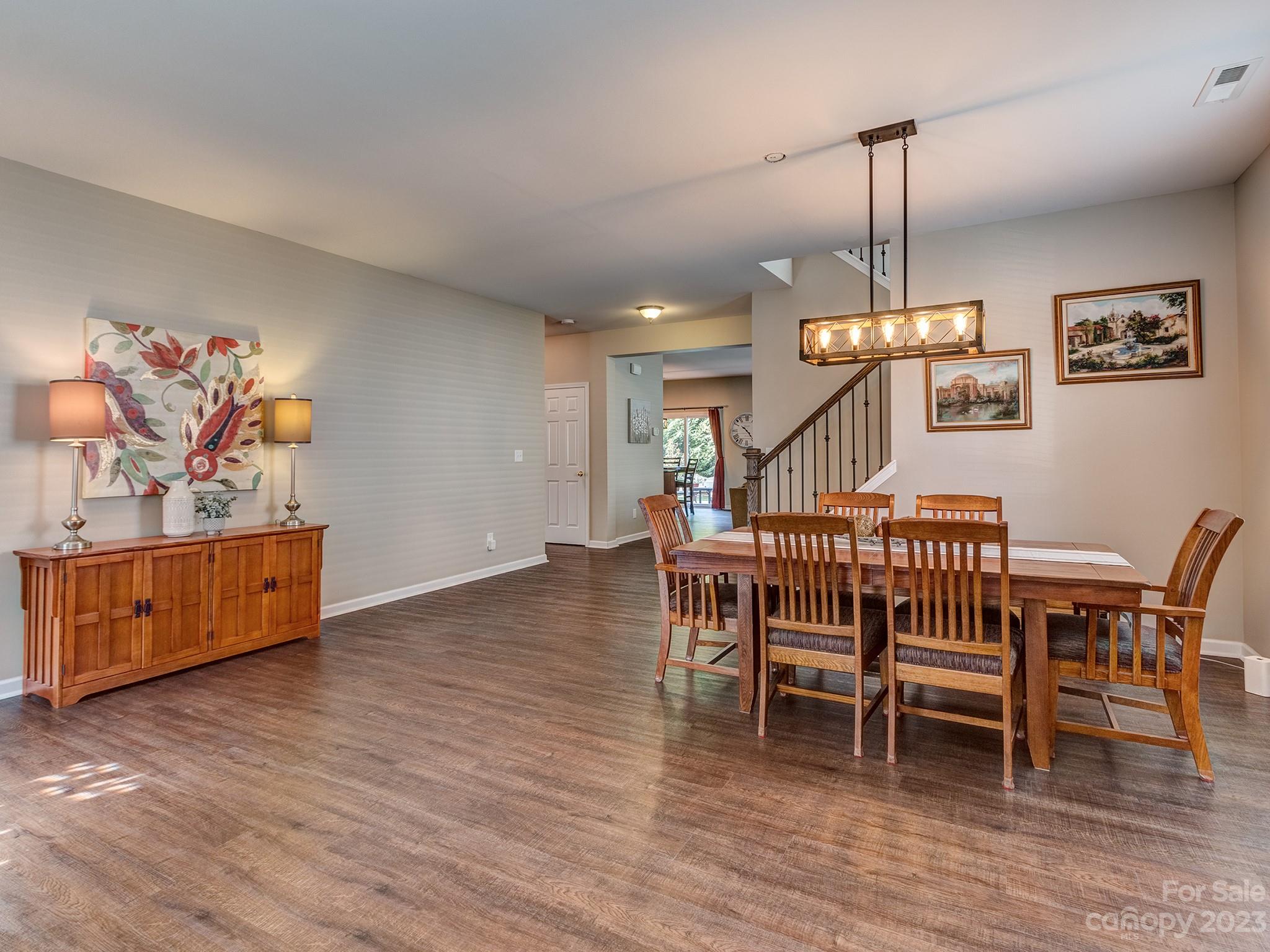 1119 Spicewood Pines Road Fort Mill, SC 29708 - Photo 8 of 38 a dining room with furniture wooden floor a rug a painting and a chandelier