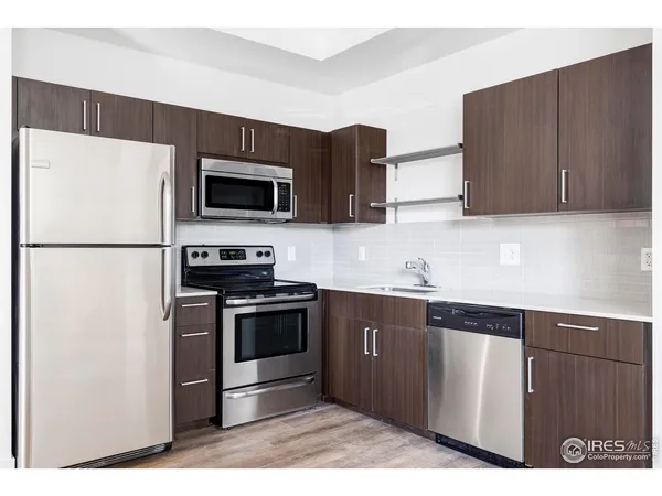 a kitchen with stainless steel appliances granite countertop a refrigerator stove a sink and dishwasher