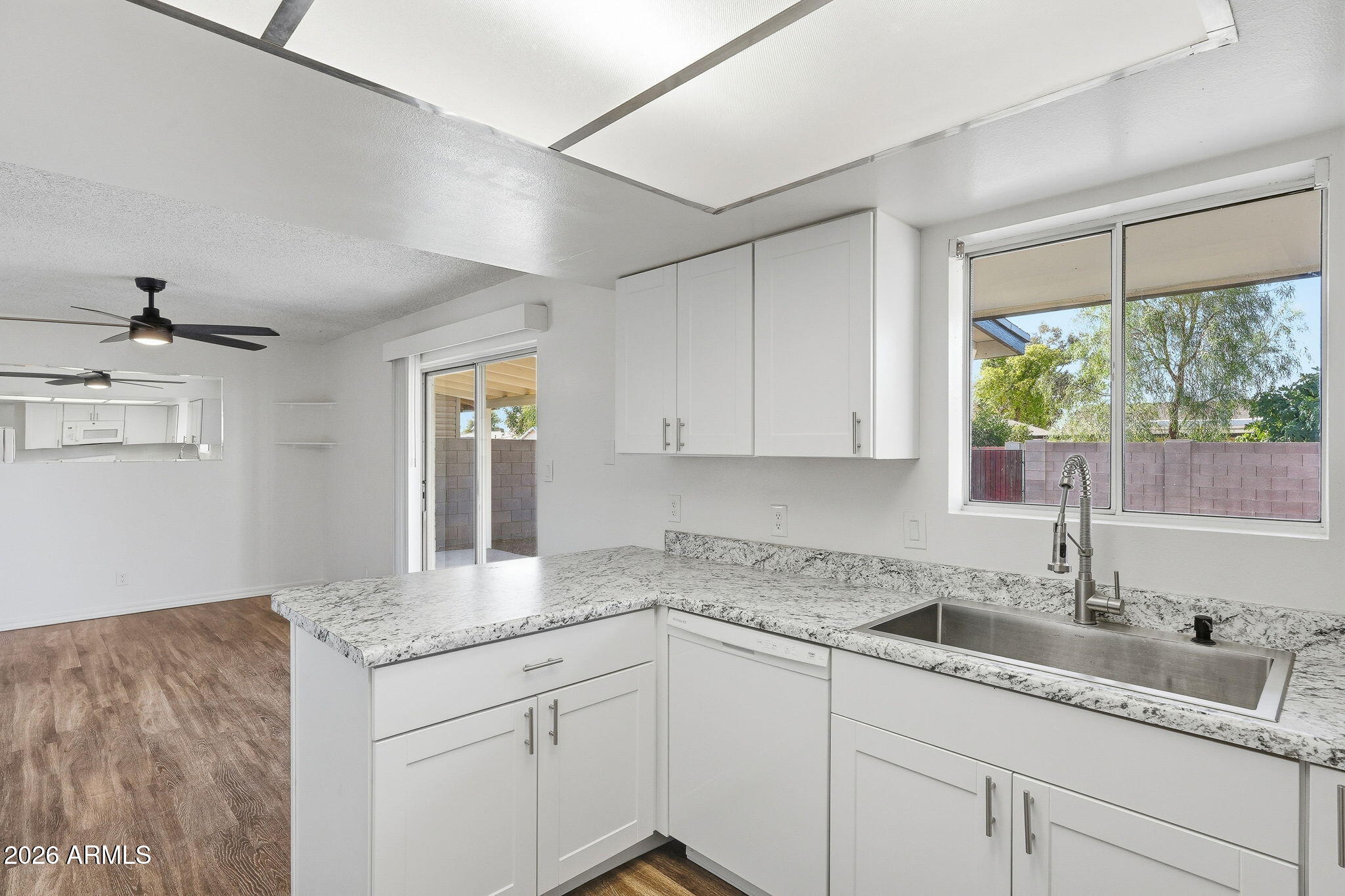 2302 East Nisbet Road Phoenix, AZ 85022 - Photo 6 of 22 a kitchen with granite countertop a sink and white cabinets