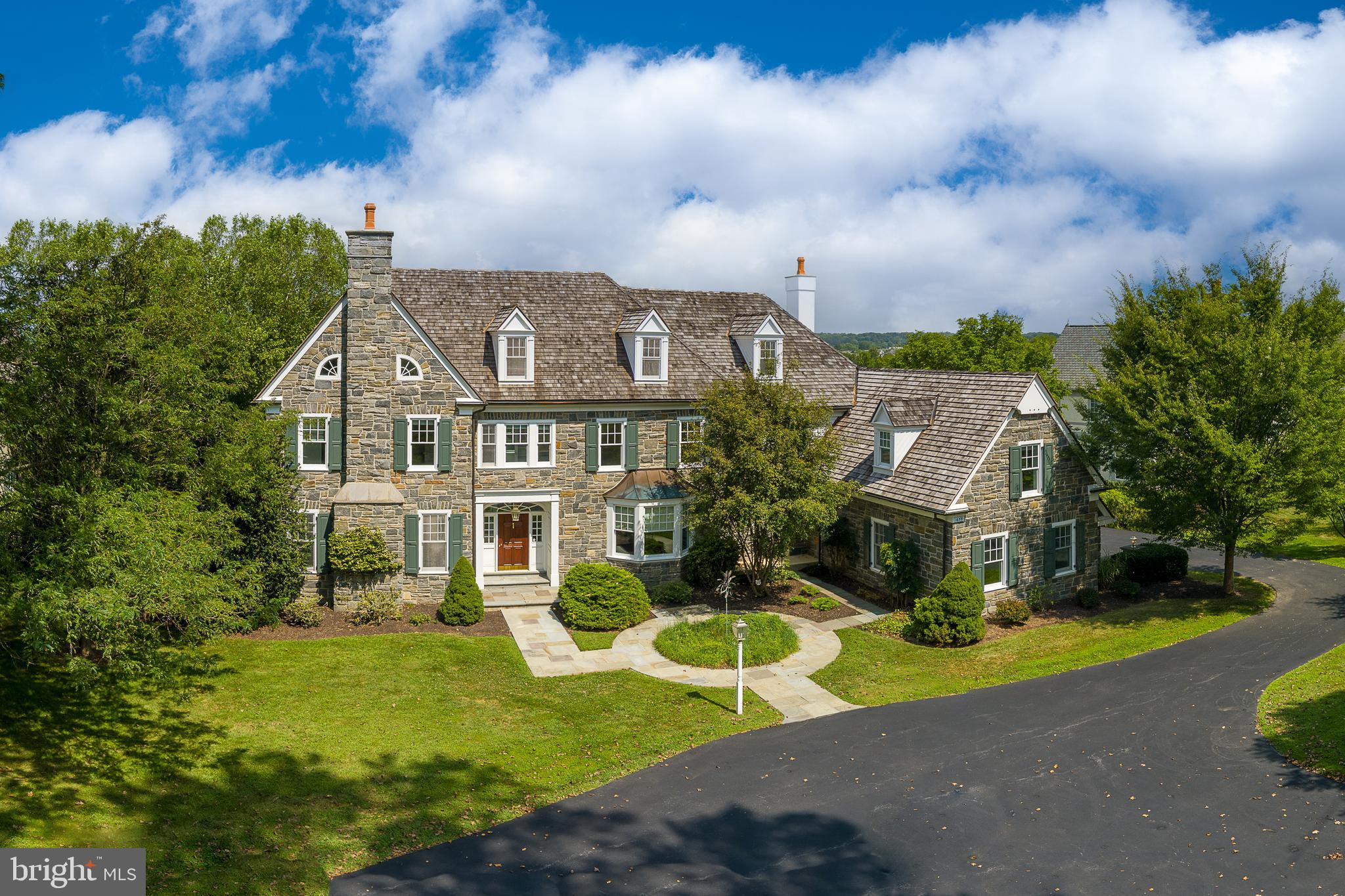 a view of a house with a big yard plants and large trees