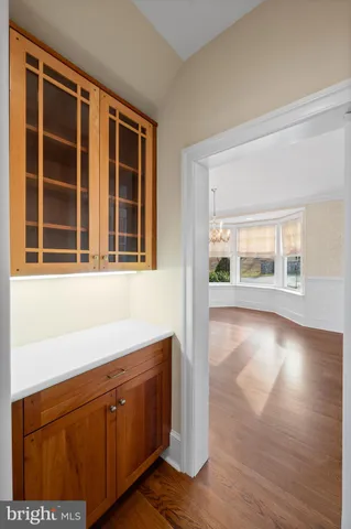 a living room with stainless steel appliances kitchen island hardwood floor and a view of kitchen