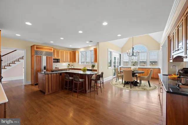 an empty room with wooden floor fireplace and windows