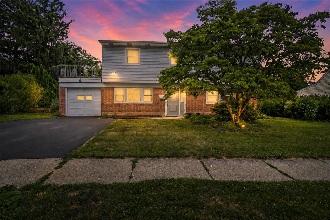 3031 Shakespeare Road Bethlehem, PA 18017 - Photo 1 of 30 A classic brick and siding residence with a balcony overlooking the front yard, nestled under a dramatic sunset sky.