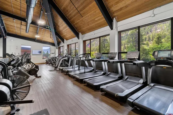a living room with furniture gym equipment and a large window