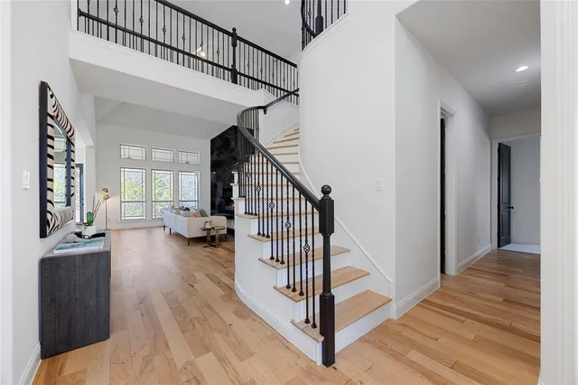 a view of a hallway with wooden floor and staircase