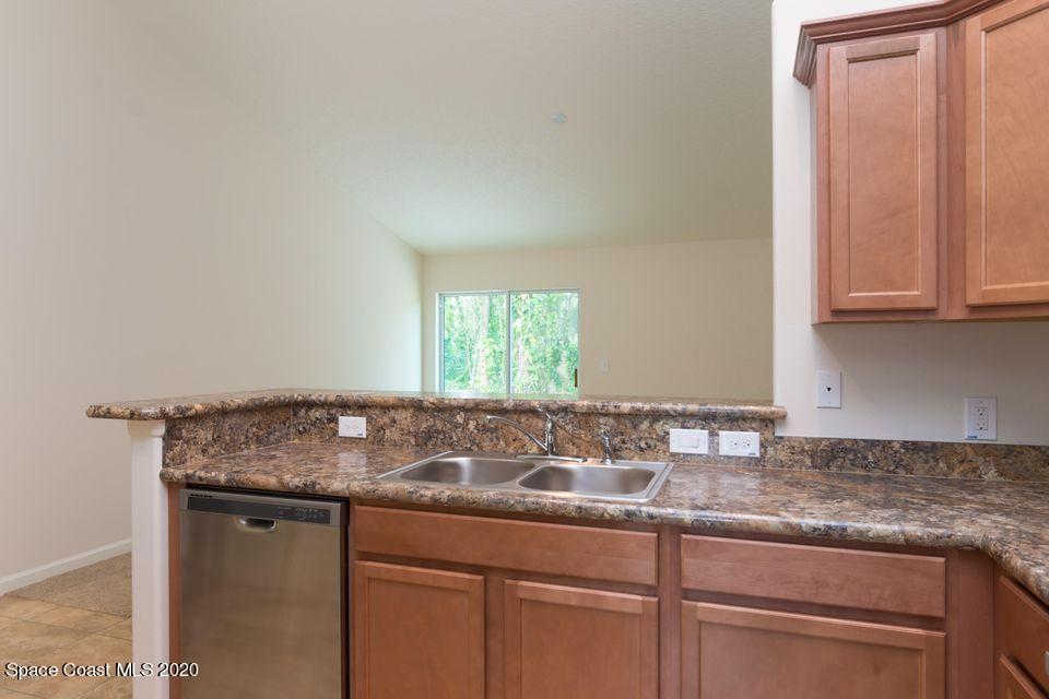 6150 Adina Road Cocoa, FL 32927 - Photo 3 of 13 a sink with granite countertop white cabinets and a granite counter top