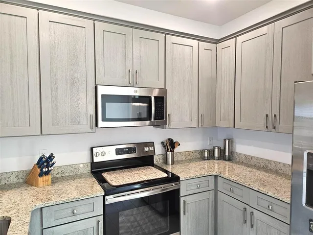 a kitchen with stainless steel appliances white cabinets and a stove top oven