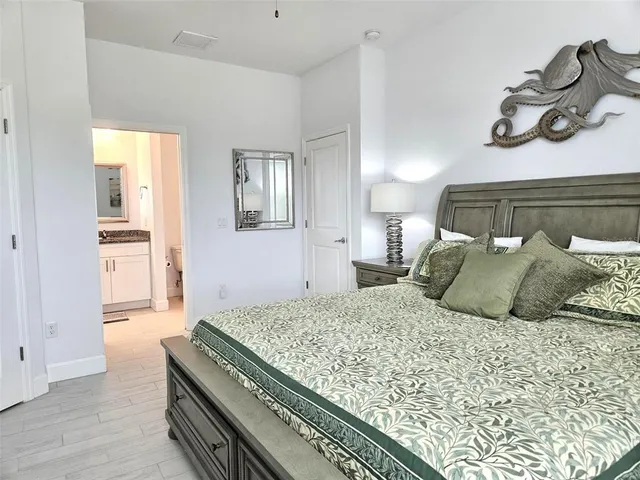 a bedroom with a bed and painting on the wall