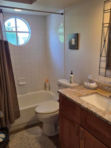 a bathroom with a granite countertop sink toilet and shower