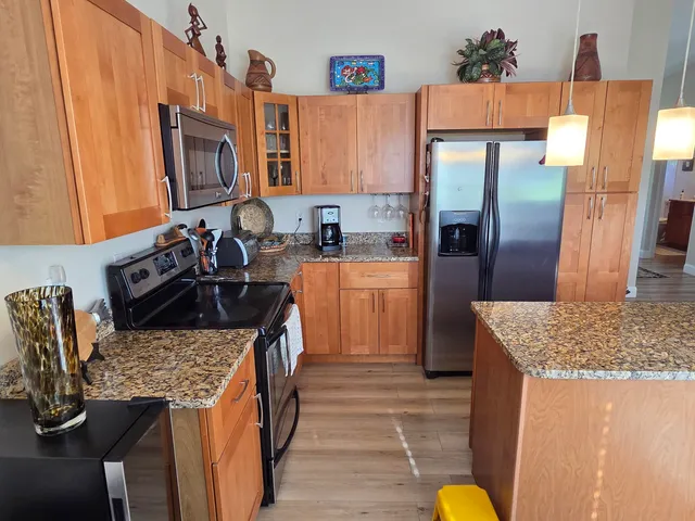 a kitchen with granite countertop a sink stove and refrigerator