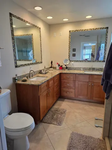 a bathroom with a toilet sink vanity and mirror