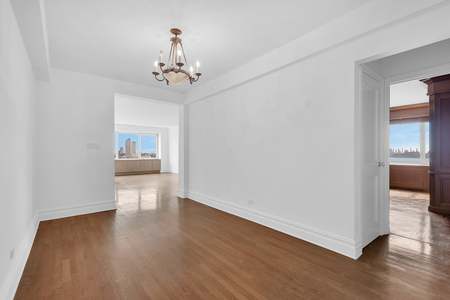 45 Sutton Place South, Unit 14F Manhattan, NY 10022 - Photo 5 of 20 a view of a room with wooden floor staircase and a kitchen