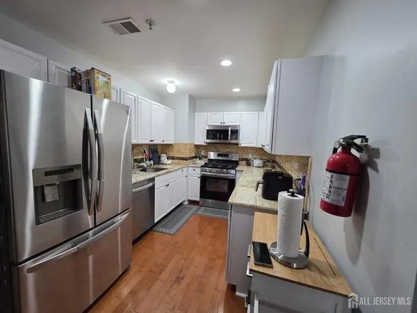 a kitchen with a refrigerator sink and wooden cabinets