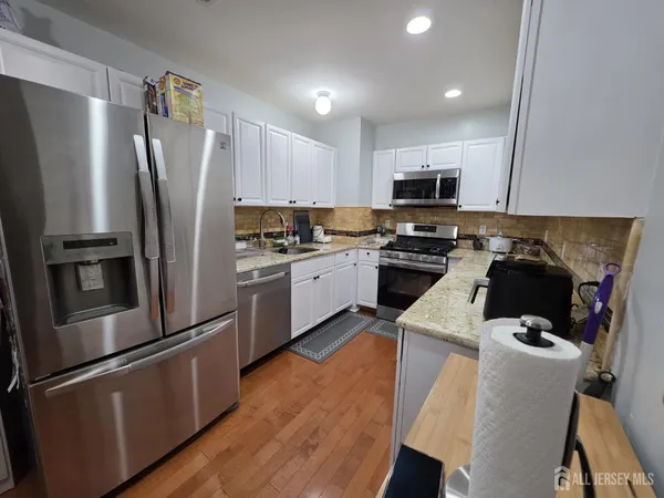 a kitchen with a refrigerator a stove top oven a sink and cabinets